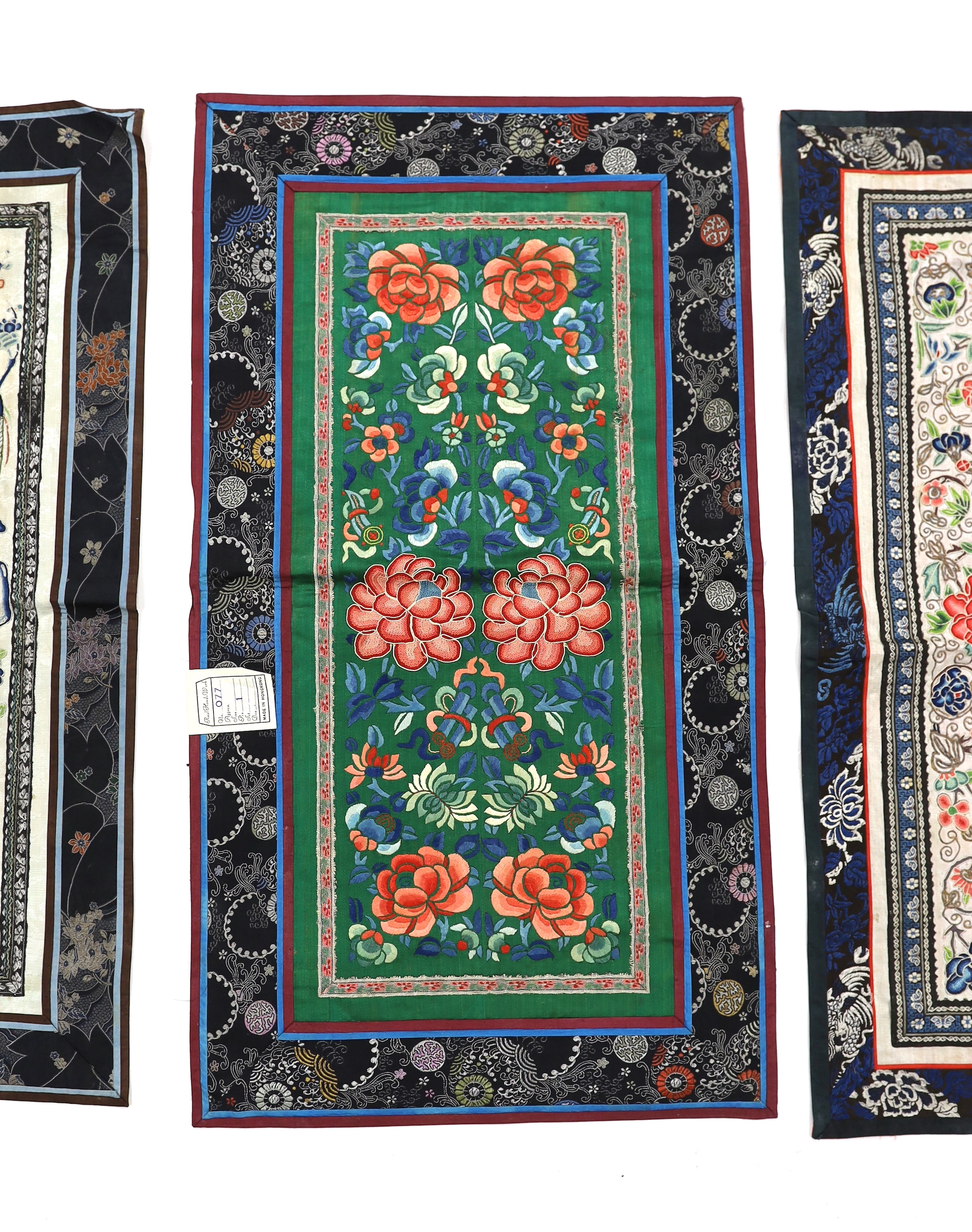 Three Beijing knot pairs of sleeve bands bordered with silk brocade and one pair embroidered with polychrome silks and gold thread longest, 73cm x 32cm including damask border